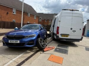 Mobile tyre technician servicing a company van tyre at a business car park